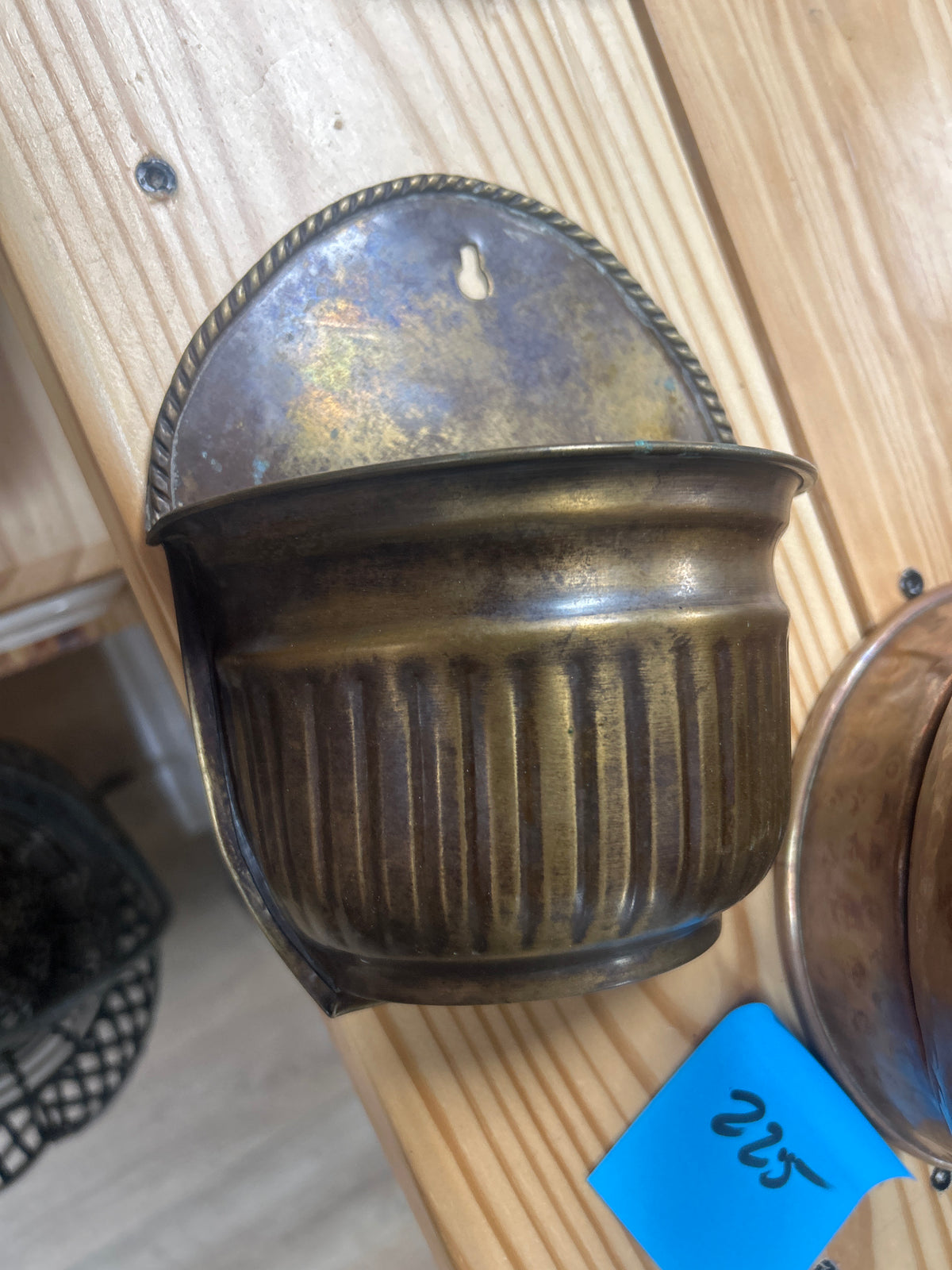 Vintage solid brass wall pocket planter features a ribbed design and a prominent patina