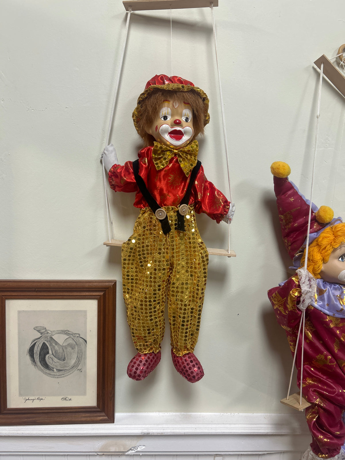 Vintage porcelain-headed clown doll featuring a painted face and a red and gold sequin costume