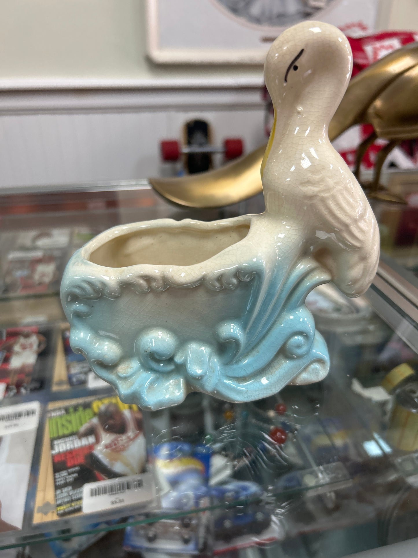 Vintage stork ceramic planter with blue accents grazing.
