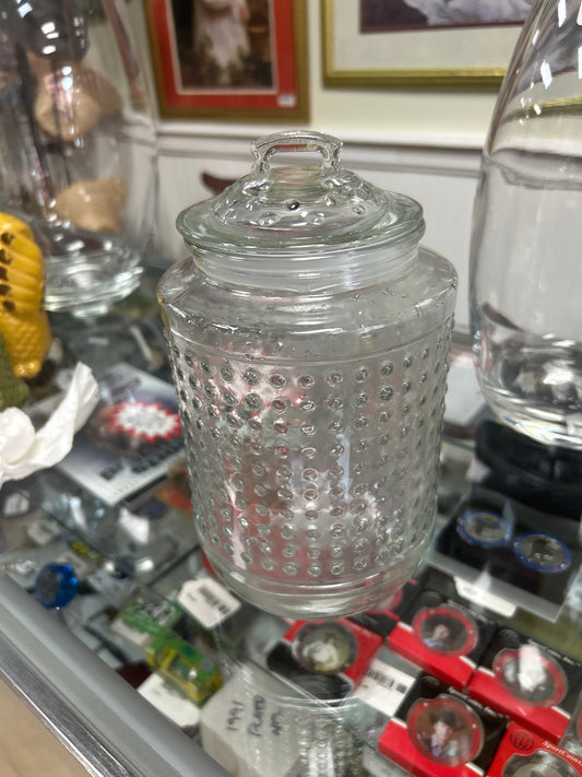 Clear glass storage jar with a beaded or polka dot texture and an airtight lid