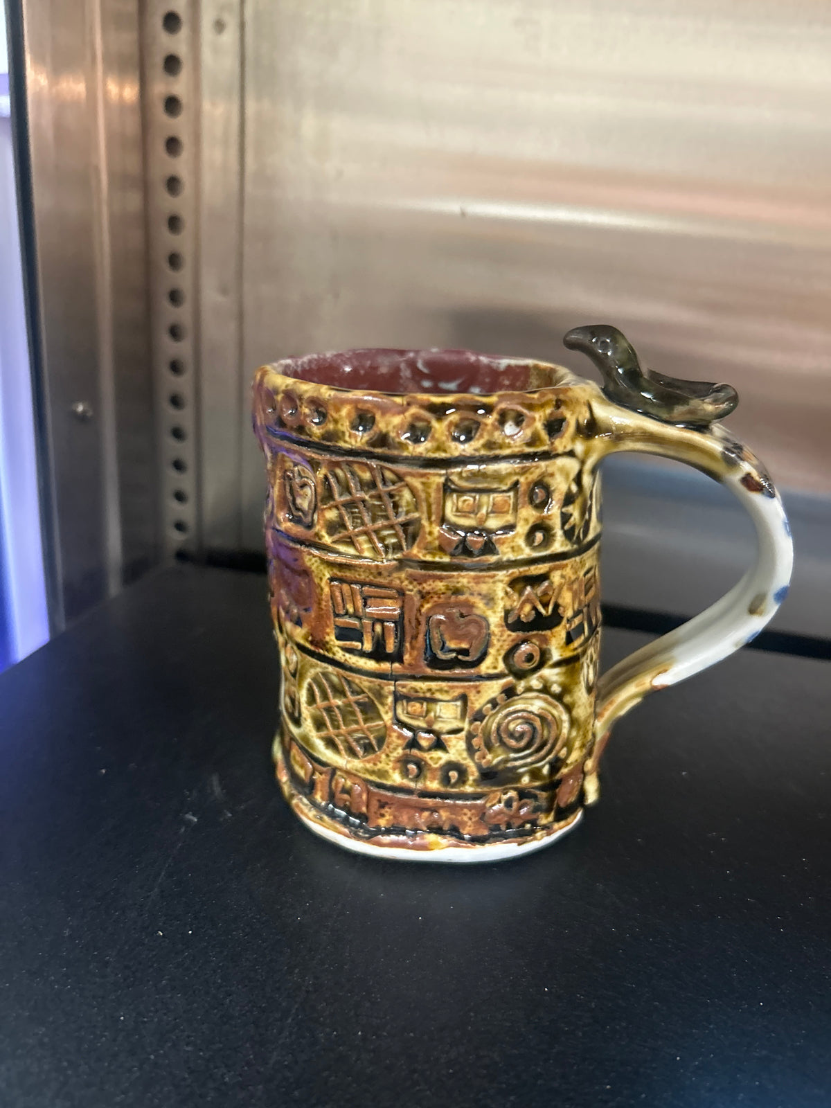 Vintage ceramic mug features a distinctive Maya-inspired relief design