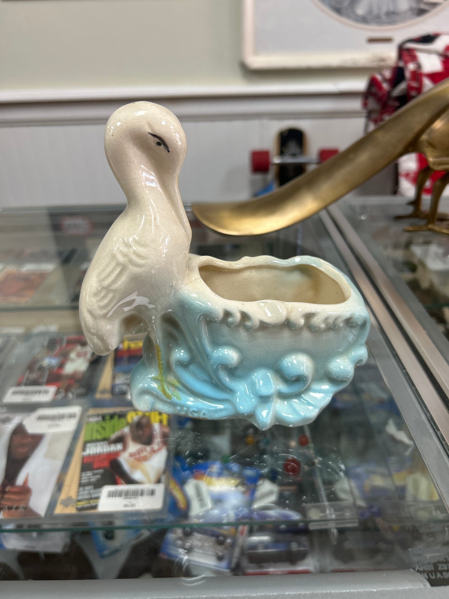 Vintage stork ceramic planter with blue accents grazing.