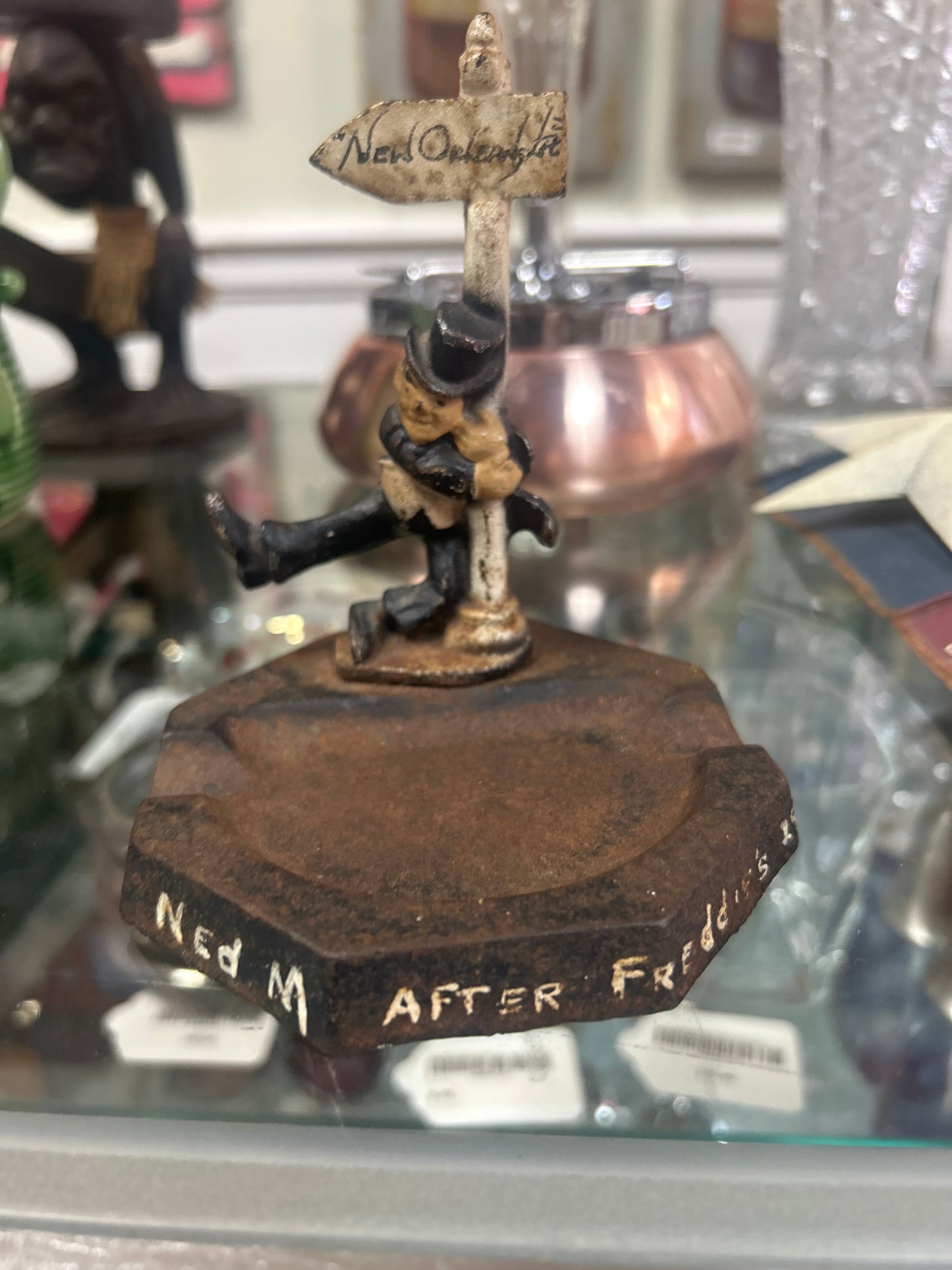 vintage cast iron ashtray featuring a "drunk on a signpost"
